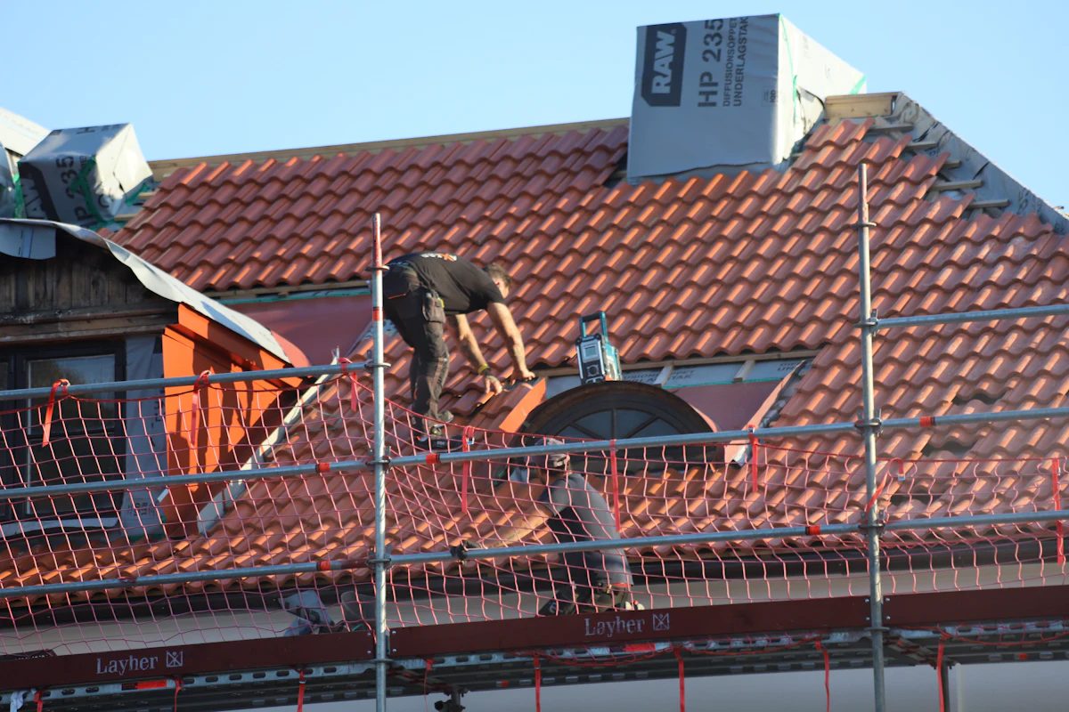 Roofer repairing storm damage on a residential roof